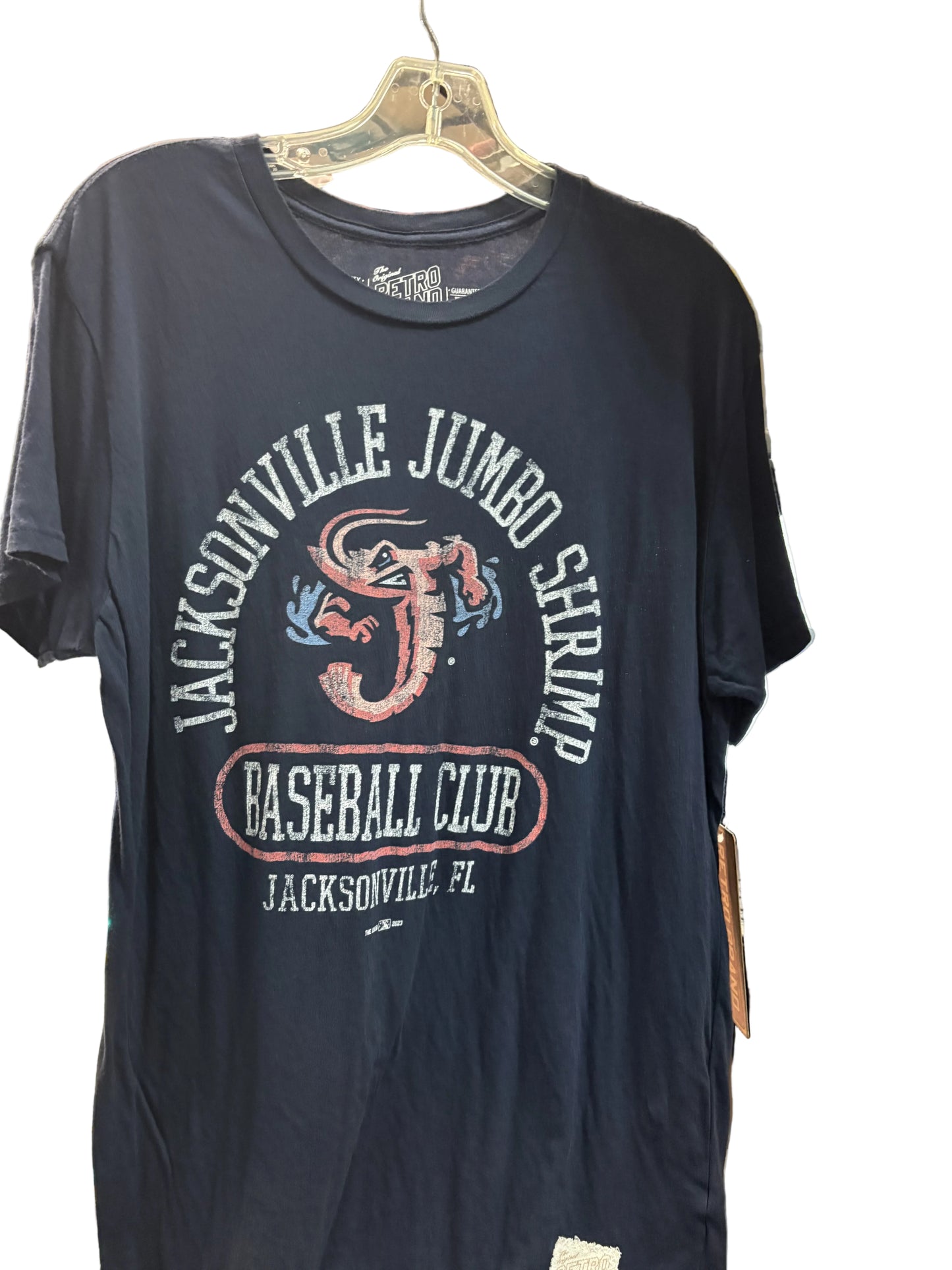 Navy blue t-shirt with 'Jacksonville Jumbo Shrimp Baseball Club' graphic on a hanger.