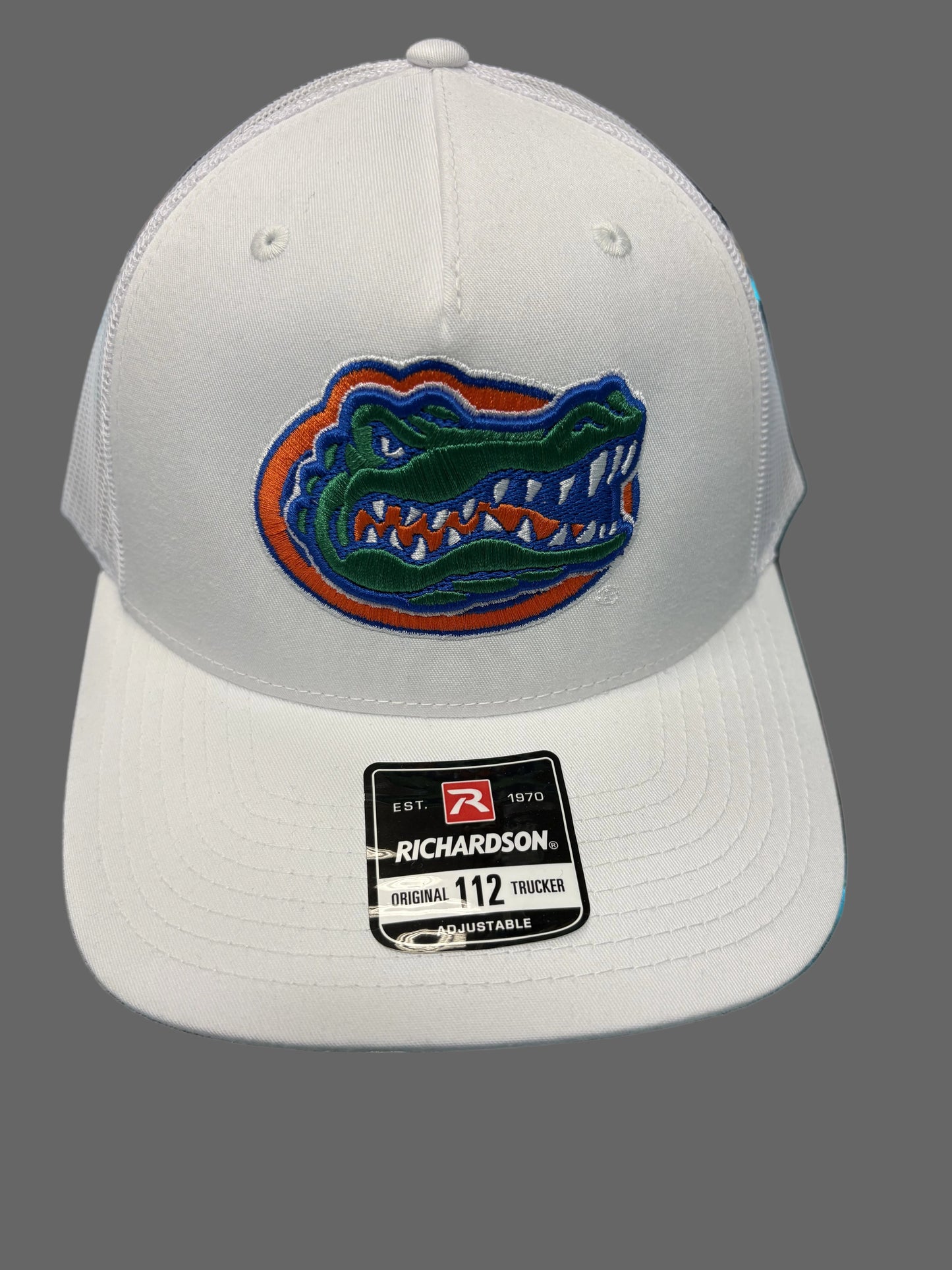 White cap with a Florida Gators logo on a reflective surface